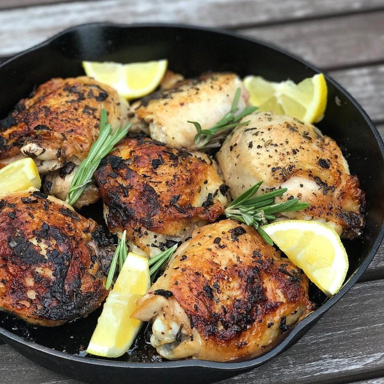 cast iron skillet with crispy garlic rosemary chicken thighs