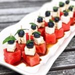 tray of fruit and feta kabobs with balsamic glaze