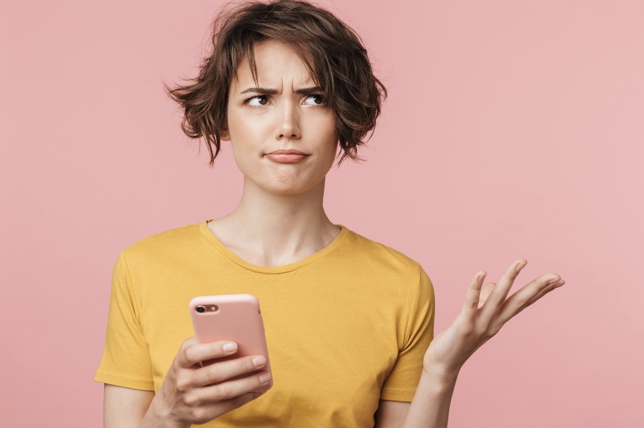 Woman looking at her phone, unsure which wellness rule actually applies to her