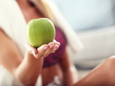 woman after pilates holding apple snack